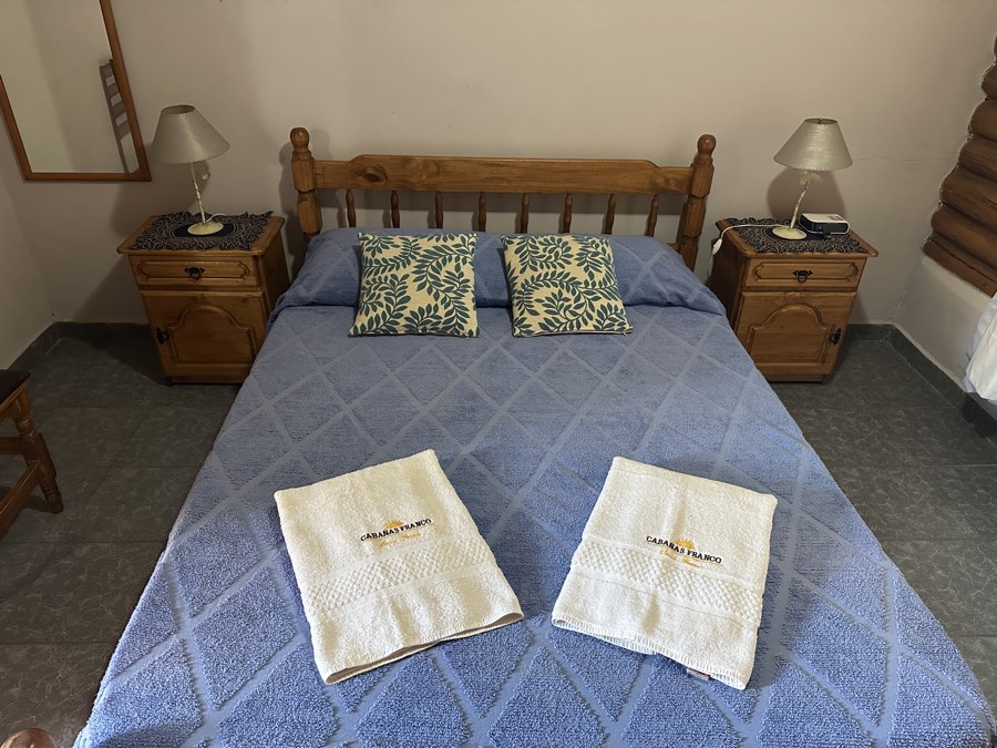Cama matrimonial con mesas de luz a ambos lados