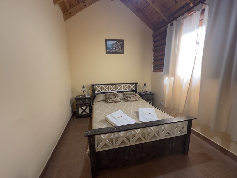 Dormitorio principal con ventanal y cortinas
