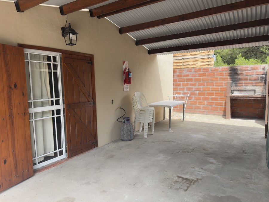 Galería con mesa, sillas y parrilla propia