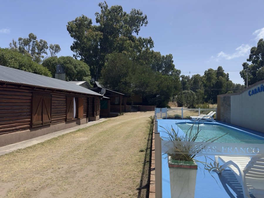 Camino interno del complejo con la pileta a un costado