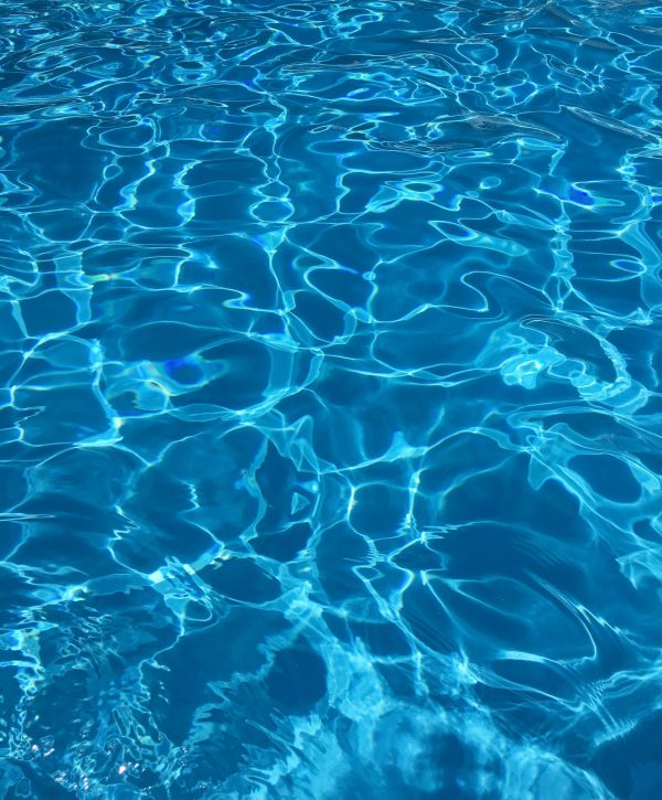 Vibrant blue swimming pool water with dynamic reflections, ideal for abstract backgrounds.